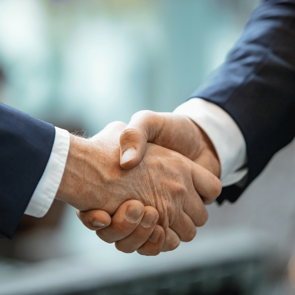 Händedruck zwischen zwei Personen als Symbol für Partnerschaft und Vertrauen.