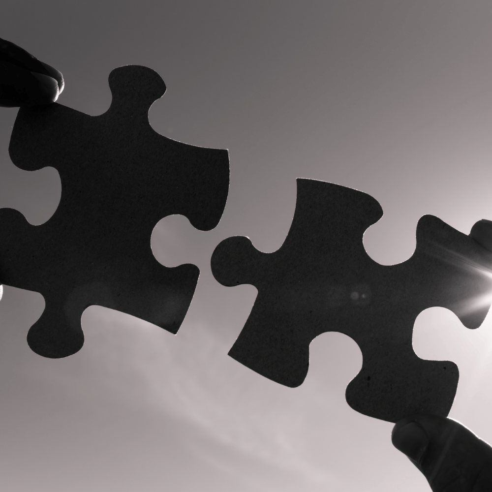 Zwei Puzzleteile werden zusammengesetzt als Symbol für Verbindung und Abstimmung.