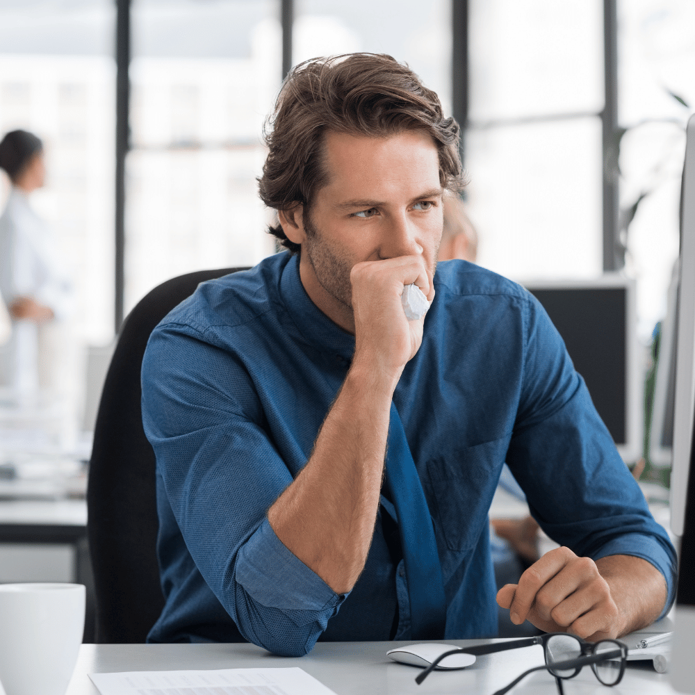 Junger Mann arbeitet am Laptop und wirkt unstrukturiert.