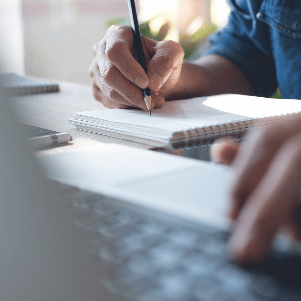 Zwei Personen sitzen am Laptop und tauschen sich über Lerninhalte aus.